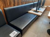 a row of black leather benches in the corner of a restaurant