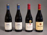 three bottles of red wine are lined up on a table