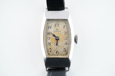 une vieille montre posée sur une surface blanche