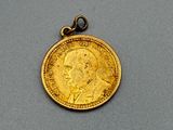 une pièce d'or sur laquelle est représenté le visage d'un homme