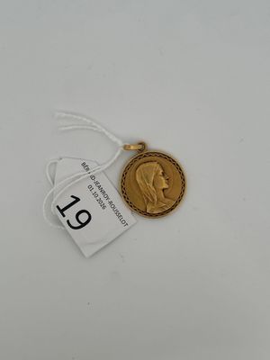 a gold coin with a tag on it sitting on top of a table