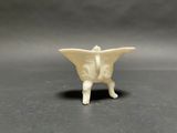 a small white figurine of a butterfly on a table