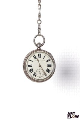 une montre de poche en argent suspendue à une chaîne sur fond blanc