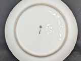 a white plate with a blue flower on it