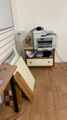 une imprimante posée sur un bureau en bois dans une pièce