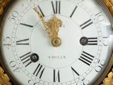 a gold clock with roman numerals on the face of it