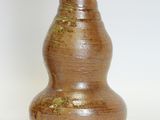 a brown vase that is sitting on a white surface