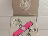 a pink keychain and a key chain in a box