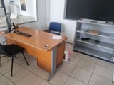un bureau avec un écran d'ordinateur et une chaise dans la pièce