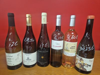 plusieurs bouteilles de vin sont alignées sur une table en bois