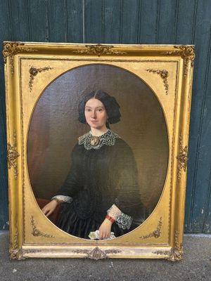 un portrait ancien représentant une femme en robe noire, dans un cadre doré