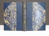 an old book with a blue cover and a gold leaf pattern