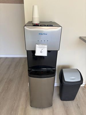 un distributeur d'eau placé à côté d'une poubelle