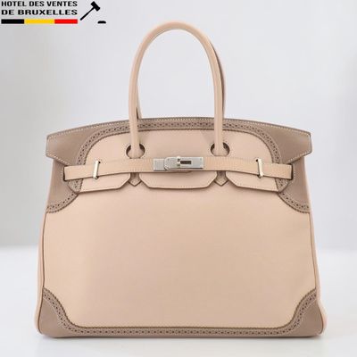 un sac à main en cuir beige muni d'une boucle métallique sur la poignée