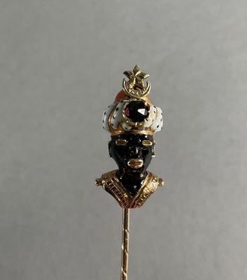 a gold stick with a black and white hat on it
