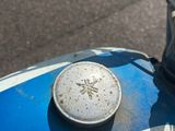 un gros plan d'une moto bleue et blanche dans la rue