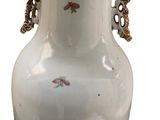 a white vase with a gold handle on a white background