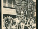 photographie en noir et blanc représentant des hommes debout devant une charrette tirée par un cheval