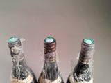 three bottles of wine wrapped in plastic wrap on a table