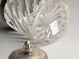a silver object on a table next to a glass vase