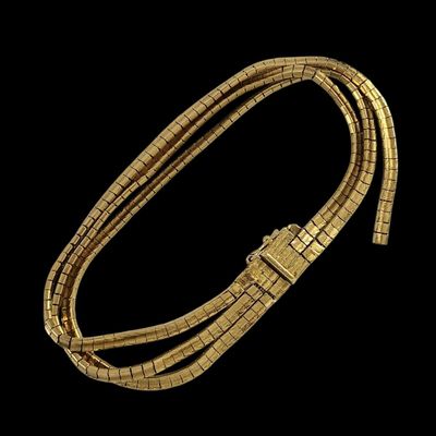 un bracelet en or avec un fermoir sur fond noir