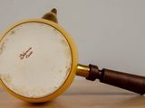 a magnifying glass with a wooden handle on a table