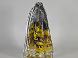 une petite bouteille en verre ornée d'un motif jaune et noir