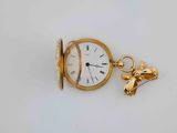 a small gold pocket watch with a chain attached to it