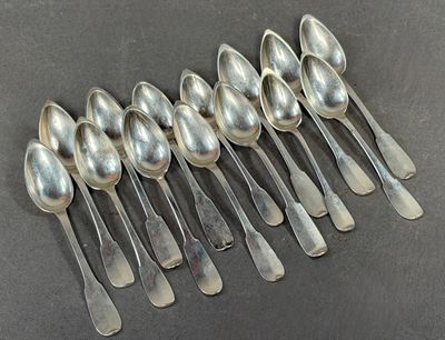six silver spoons are lined up in a row on a table