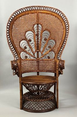 an antique wicker peacock chair with a wooden seat and foot rest
