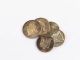 some coins are sitting on a white surface with a white background