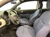 the interior of a small car with blue seats and a steering wheel