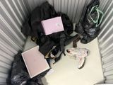un sac à dos, un ordinateur portable, une paire de chaussures et un sac à dos posé par terre