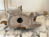 a birdhouse made out of cement on a marble counter top