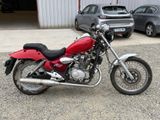 a red motorcycle parked in front of a building
