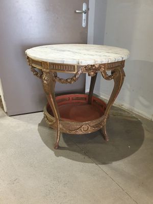 a small table with a marble top in the corner of a room