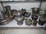a glass shelf with a lot of silver items on it