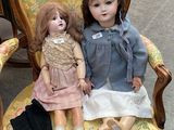 two dolls that are sitting on a chair together