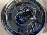 a close up view of a blue glass with writing on it