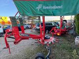 a red trailer with a green cover on it parked in a parking lot