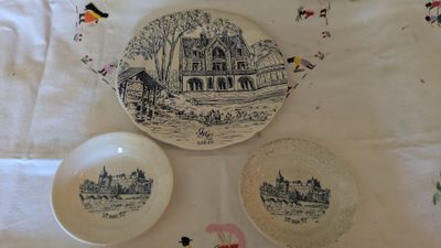 three plates on the table with a picture of a house on them