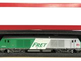 un train vert et blanc dans une boîte posée sur une surface blanche