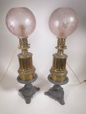 paire de lampes de table en verre rose sur des pieds en fonte