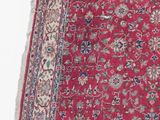 a red rug with a floral design on it