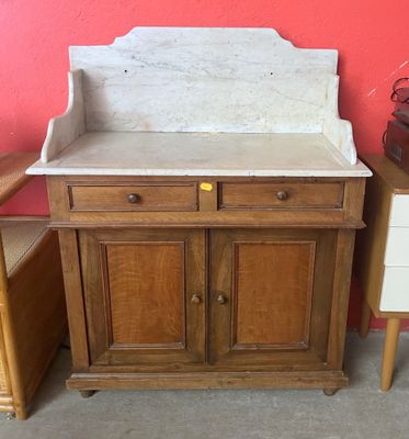 une armoire en bois avec un plateau en marbre, à côté d'une commode
