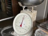 une balance sur laquelle est posé un bol, posée sur une table