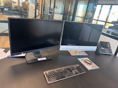 deux écrans d'ordinateur et un clavier sur un bureau