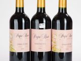 trois bouteilles de vin posées l'une à côté de l'autre sur une table