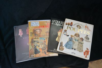three children ' s books are sitting on a black cloth