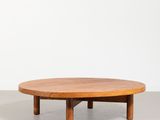 une table basse ronde avec des pieds en bois et un plateau en bois